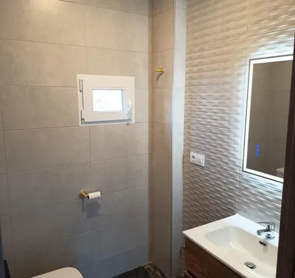 Baño reformado con mueble y revestimientos claros