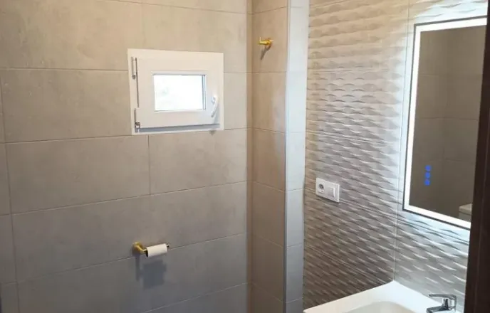 Baño reformado con mueble y revestimientos claros